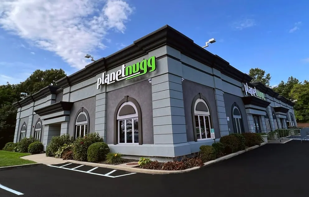 Planet Nugg dispensary exterior with green sign and arched windows in Farmingdale